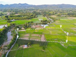 Land plot in aerial view, Top view land green field agriculture plant with pins, pin location icon for housing subdivision residential development owned sale rent buy or investment countryside suburbs